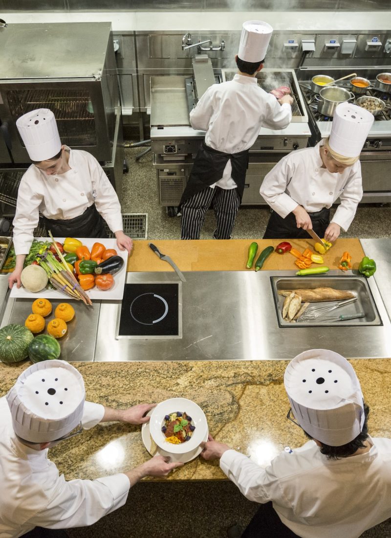 a-view-looking-down-on-a-crew-of-chefs-working-in-a-commercial-kitchen-.jpg a-view-looking-down-on-a-crew-of-chefs-working-in-a-commercial-kitchen-.jpg